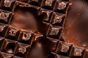 Dark chocolate with a heterogeneous surface and white coconut filling. Close-up chocolate.