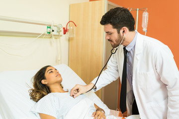 Fototapeta premium Male Healthcare Worker Treating Patient In Hospital