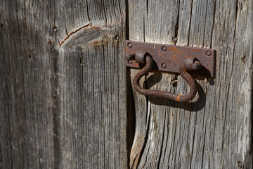 An old metal handle on a wooden door