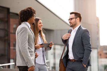 Three people in front of their workplace.