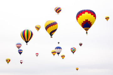 USA, New Mexico, Albuquerque. International Balloon Festival. Hot air balloons rise into a white sky after launch.