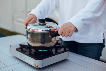 Placing casserole in camping gas