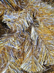 Golden and silver tinsel background with selective focus. Sparkling tinsel. Christmas decoration. New year abstract background with shiny glittering tinsels. Holiday backdrop