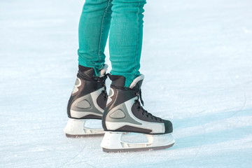 Legs of a man skating on an ice rink. Hobbies and sports. Vacations and winter activities