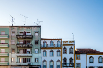 Fototapeta na wymiar Contrasting Portuguese apartment building facades in profile against blue sky