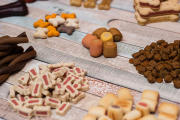 Pet food, snacks for dogs. Dog tasty colored biscuits on wooden background