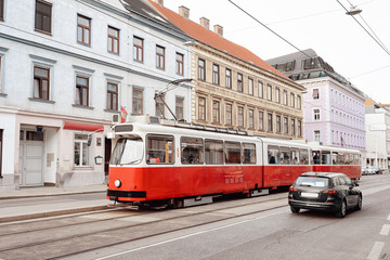 Fototapeta na wymiar Typical red tram on road in Mariahilfer Strasse in Vienna