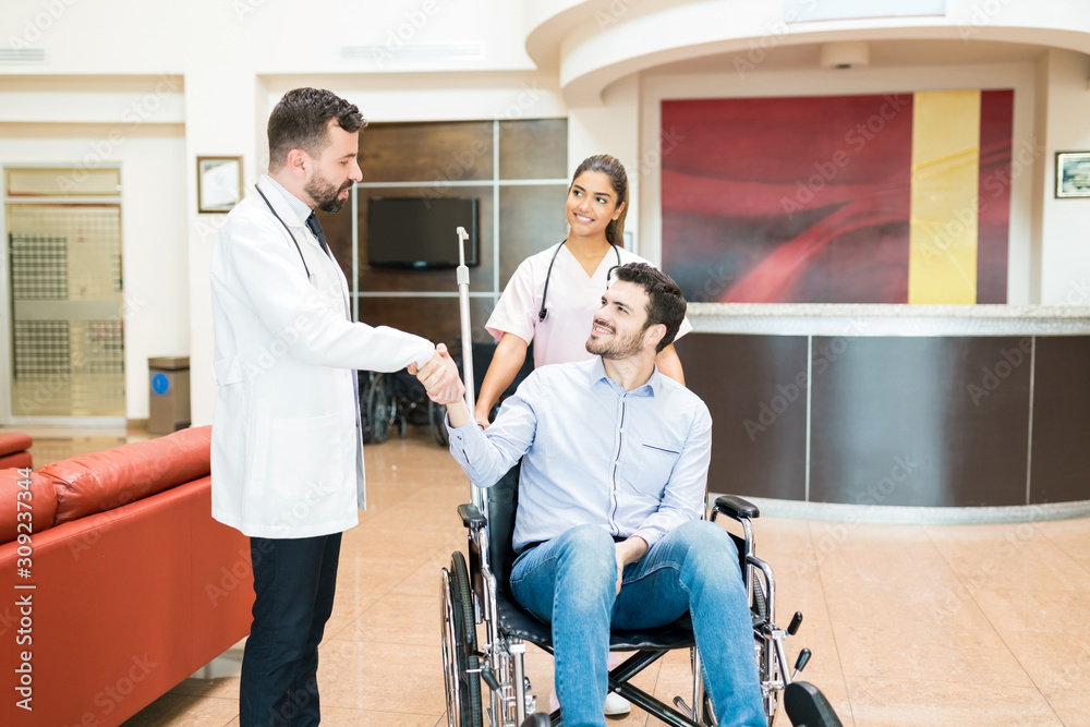 Wall mural man greeting goodbye to doctors at hospital lobby