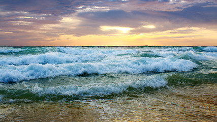 Fototapeta na wymiar Beautiful sunset on the beach. The surf pounds the shore. Phuket, Thailand