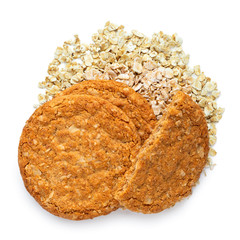 Two and half crunchy oat and wholemeal biscuits on a heap of oats isolated on white. Top view.