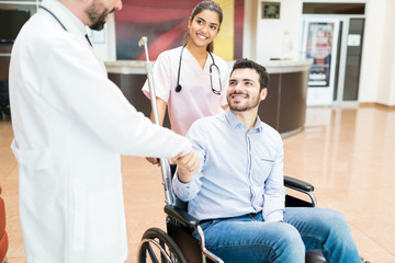 Recovered Patient Greeting Goodbye To Medical Team At Hospital