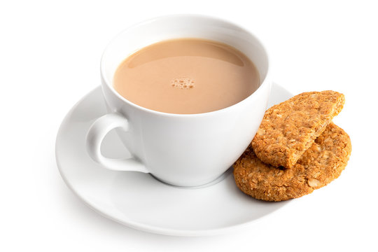 Cup of tea with milk and one and half crunchy oat and wholemeal biscuits isolated on white. White porcelain.