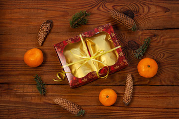 Christmas gift in golden pouch bags, red present box wrapped with New year decorations on rustic wooden background. Trendy tea,coffee packaging mockup, flatlay style.Copy space,winter holidays concept