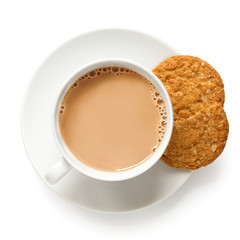 Cup of tea with milk and one and half crunchy oat and wholemeal biscuits isolated on white. White porcelain. Top view. - 309237931