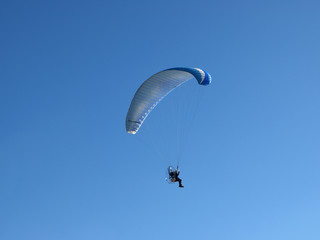 motor paragliding on a sunny day with an intense blue sky