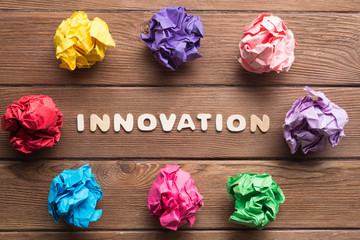 colorful crampled paper ball placed in circle on wooden table