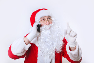 Portrait of happy Santa Claus talking on phone and showing up