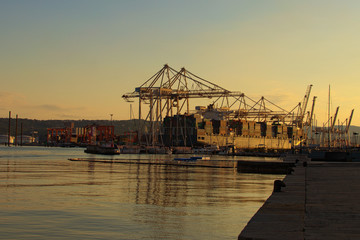 Koper, Slovenia-September 29, 2019:Picturesque landscape of harbor of Koper during sunrise. Container ship loading by containers. Import, export and business logistic. International water transport