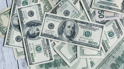 Hundred dollar banknotes spinning on a table. Rotation 100 dollar bills money. Background with money american dollars close-up 4k - Powered by Adobe