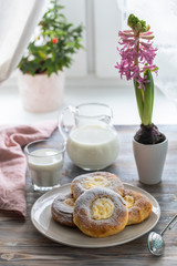Cheesecake rolls for Breakfast on a wooden table by the window with a cat