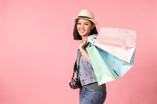 Tourist woman in summer casual clothes.Asian Smiling woman .Passenger traveling abroad to travel on pink background.She going to summer vacation.Travel trip funny Credit card on holiday.