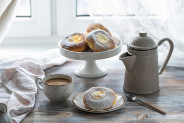 Cheesecake rolls for Breakfast on a wooden table by the window with a cat
