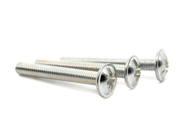 Stainless steel machine screws isolated on a white background. Metal screws close-up, selective focus.