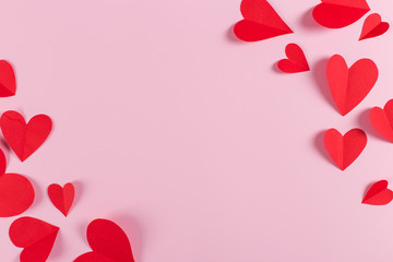 Red hearts are handmade on pink background. Preparation for Valentine's Day with a place for text. Copy space.