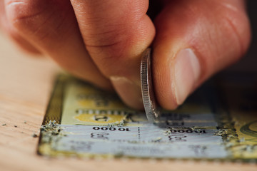 close up view of hand of gambler stretching lottery ticket