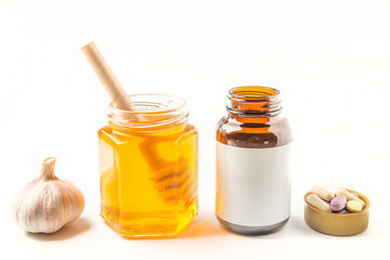 Honey and garlic with pills on a white background