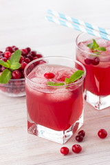 Red coctail with cranberry, vodka and ice on a white background. Refreshment drink.