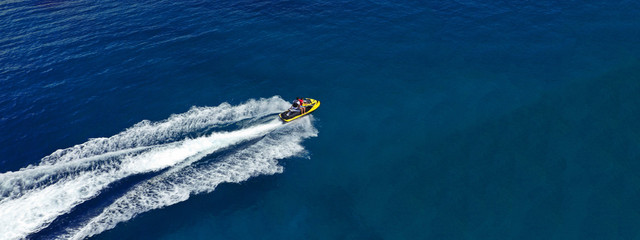 Aerial photo of jet ski with couple cruising in high speed in Caribbean tropical crystal clear...