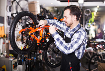 Fototapeta na wymiar Mechanic in bicycles store workshop