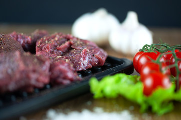 fresh grilled meat with cherry tomatoes, lettuce, garlic and seasonings
