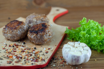 semi-finished cutlets on a cutting Board with seasonings and herbs