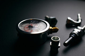 gauge and hydraulic fittings on a black background