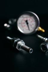 gauge and hydraulic fittings on a black background