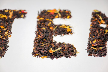 word black tea tea with fruit pieces and flower petals macro isolate