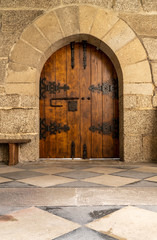 Fototapeta na wymiar Solid wood and reinforced arched door inside historic monastery in Guimaraes