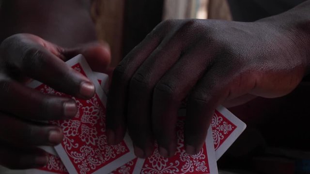 Close-up of dark male hands sorting out playing cards