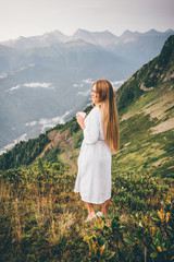 Side view woman in SPA bathrobe standing in the beautiful mountain view. Travel and healthy lifestyle and beauty outdoors. - obrazy, fototapety, plakaty