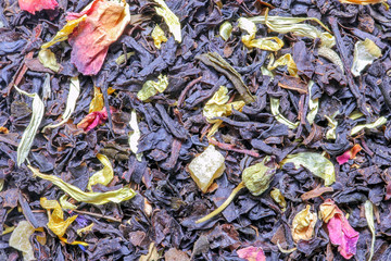 black tea with fruit pieces and flower petals macro isolate
