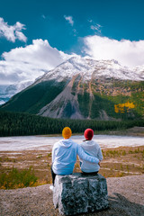 couple traveling in the Canadian rockies passing mountains and glaciers on the icefield parkway...