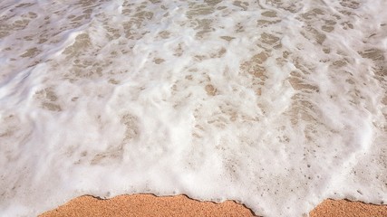 abstract background of sea waves, on golden sand, white sea foam, sunlight