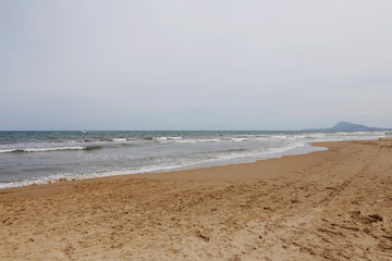 Beautiful sand beach in Oliva Valencia, Spain. Nature reflection in the sea water.  Mediterranean Sea shore. European beach. 