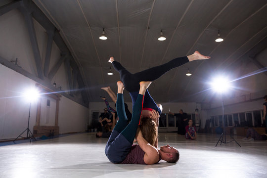 Couple does acroyoga, physical practice yoga and acrobatics. Balance and concentration couple. Men and woman, pair acroyoga flexibility workout. Fit active pair yoga time. Meditation, yoga, asanas - Powered by Adobe