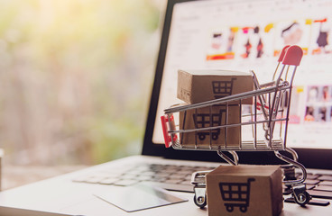 Shopping online concept - Parcel or Paper cartons with a shopping cart logo in a trolley on a...