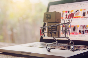 Shopping online concept - Parcel or Paper cartons with a shopping cart logo in a trolley on a...