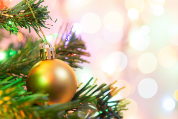Christmas decoration. Hanging gold balls on pine branches Christmas tree garland and ornaments over abstract bokeh background with copy space..