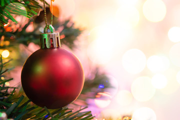 Christmas decoration. Hanging red balls on pine branches Christmas tree garland and ornaments over abstract bokeh background with copy space.